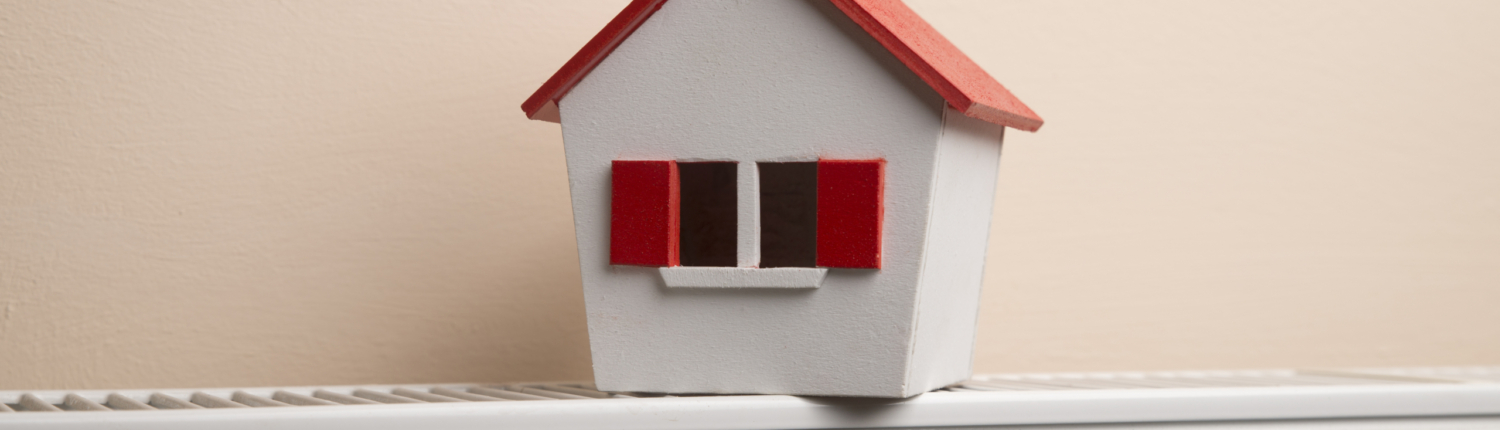 Hausmodell steht auf einem Heizkörper - Martina Wagner Immobilien