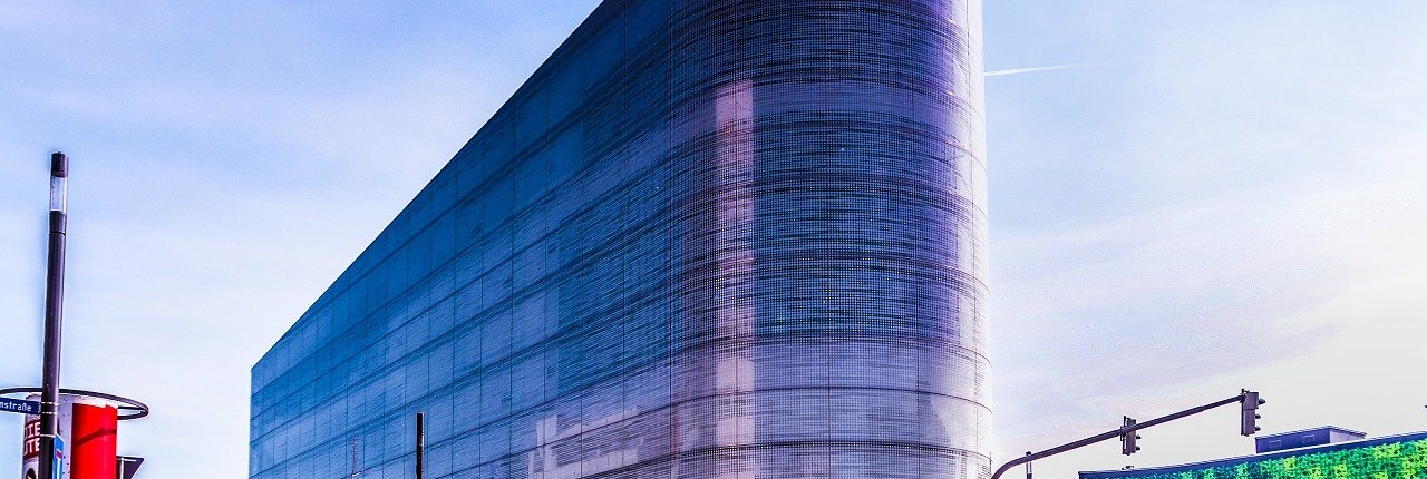 Das Gebäude des Forums in der Koblenzer Innenstadt am Tag mit Fußgängern und einigen Bussen - Martina Wagner Immobilien