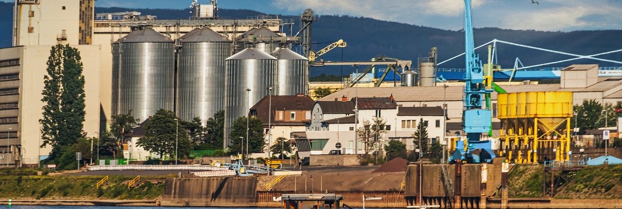 Blick auf die gewerbliche Hafenanlage in Andernach am Rhein mit Rhein im Vordergrund - Martina Wagner Immobilien