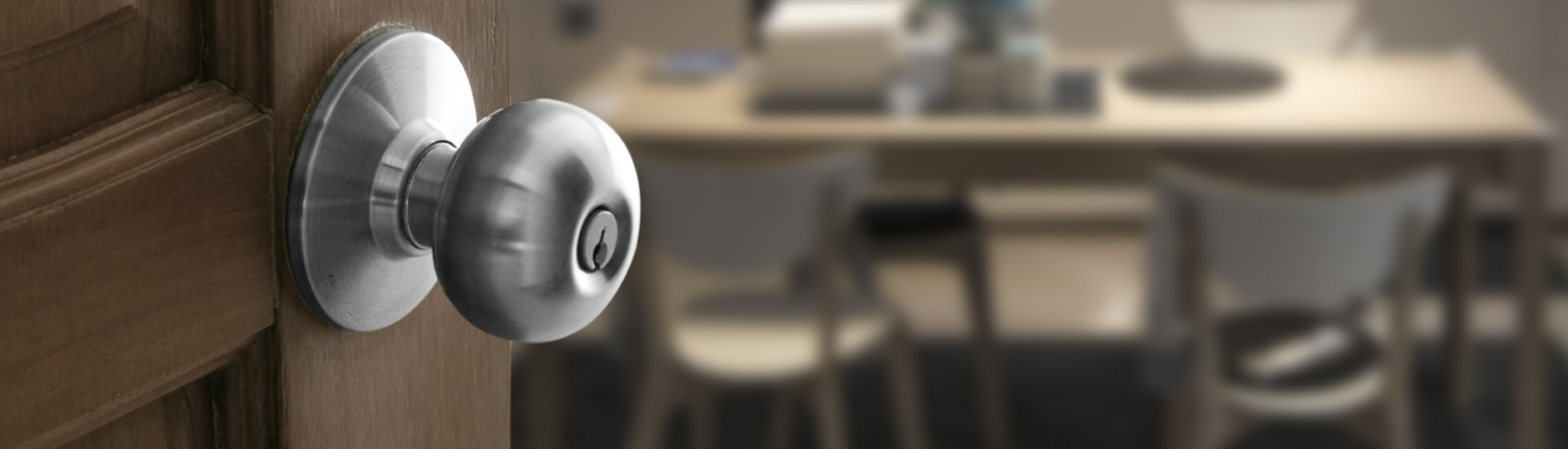 Willkommen zu Hause. Eine offene Tür am linken Bildrand öffnet sich zu einer verschwommenen Küche - Martina Wagner Immobilien