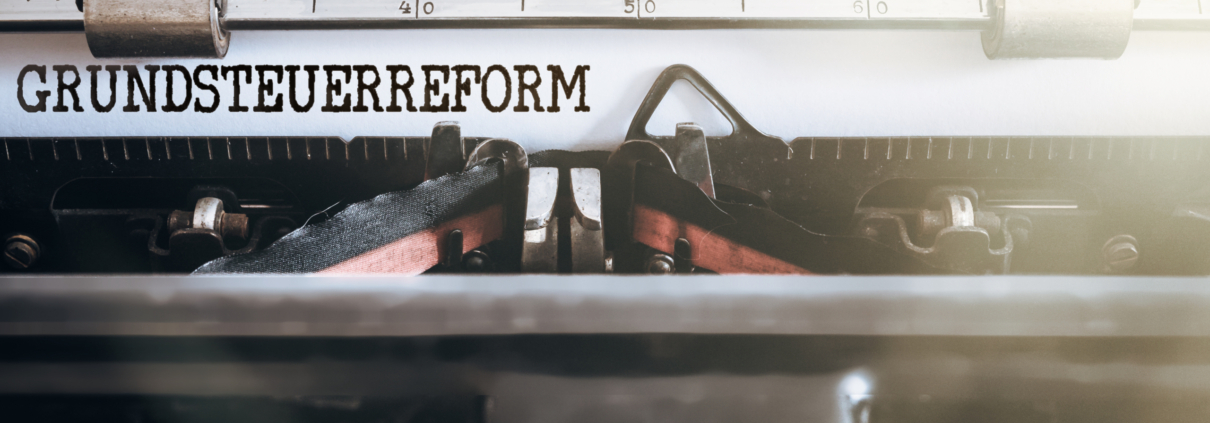 Der Schreibbereich einer alten Schreibmaschine zeigt im Zoom das Wort Grundsteuerreform getippt