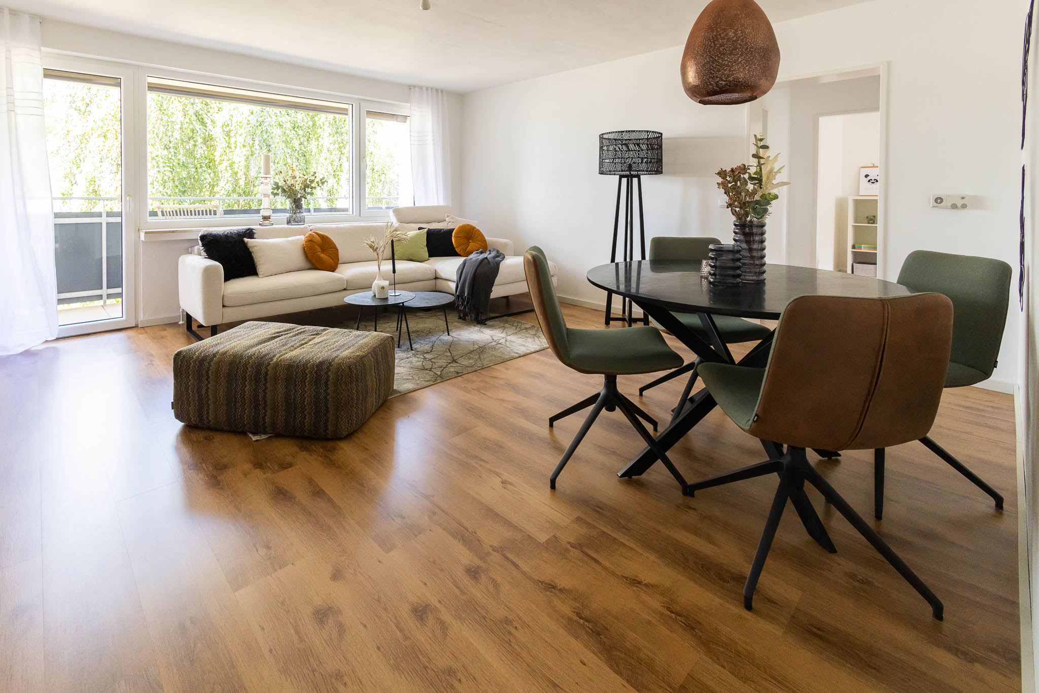 Blick auf den Wohn-Essbereich, mit Sofaecke und Essecke möbliert, sehr hell und ansprechend - Martina Wagner Immobilien