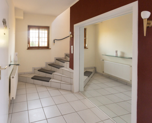 Eingangsbereich mit großen Spiegel und Blick auf den Treppenaufgang - Martina Wagner Immobilien