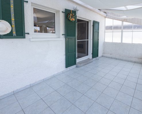 Wintergarten mit grünen Fensterläden im Landhausstil - Martina Wagner Immobilien