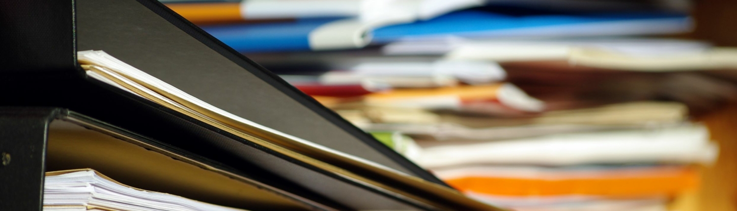 Dokumente und Unterlagen Ein Stapel mit Ordnern und Unterlagen ist verschwommen zu sehen