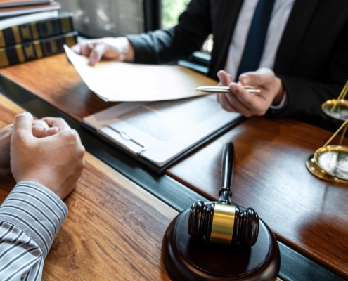 Vorgang beim Notar wird stilisiert dargestellt. Zwei Parteien sitzen an einem Tisch, man sieht keine Gesichter