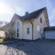Seitliche Außenansicht der Immobilie in Oberlützingen. Gepflasterte Einfahrt, Garage und Vorgarten sind zu sehen