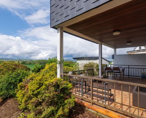 seitlicher Blick auf das Haus mit Terrasse und Garten