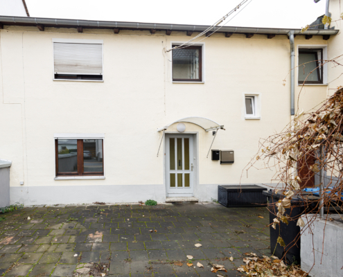 Außenansicht Immobilie Frontansicht einer Altbauimmobilie mit Hof im Vordergrund.